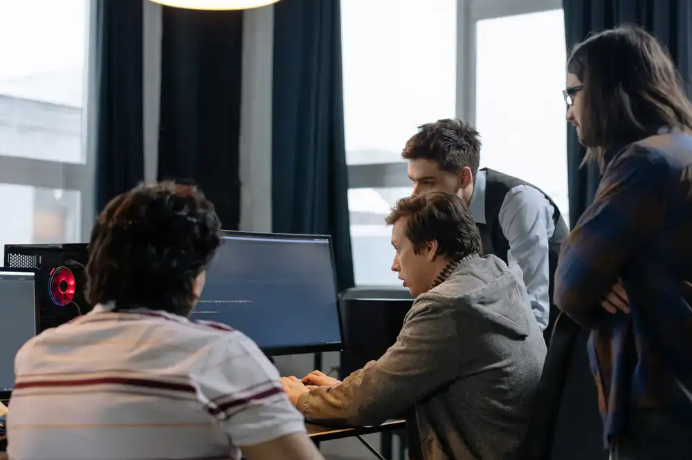 Happy children working together on a coding project at a computer screen