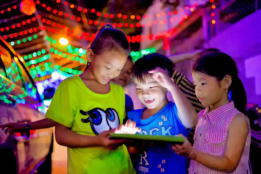 Group of kids celebrating around a computer screen