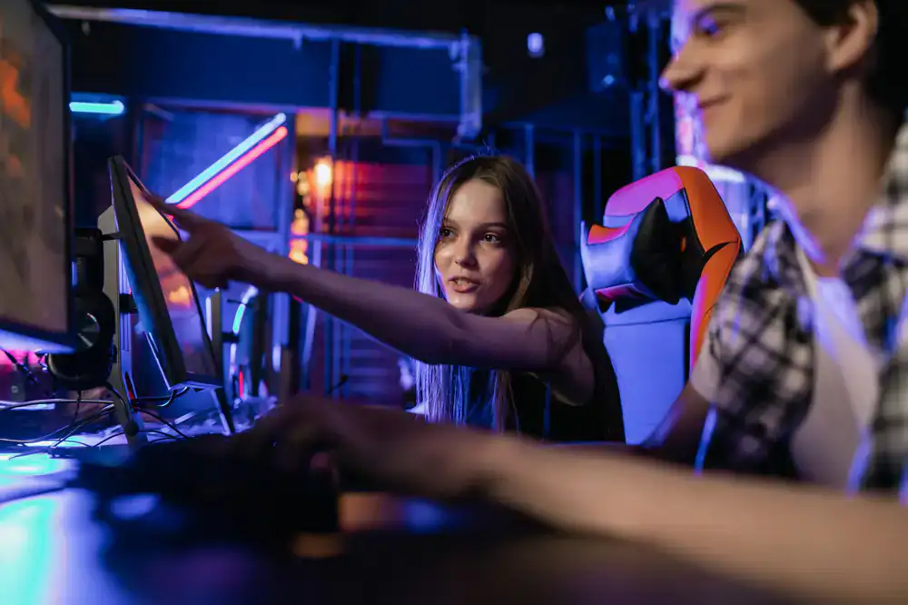 A child proudly pointing to their completed video game on screen